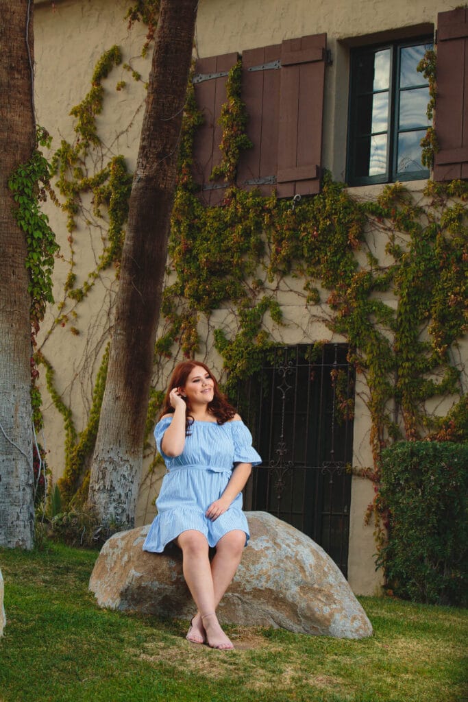 QUINCEAÑERA & SWEET SIXTEEN | Fotografía y Video en Mexicali | 9 | Los mejores fotógrafos y videógrafos en Mexicali Celia en una pose relajada sobre una roca en el jardín del Colorado River, Mexicali, durante su sesión de fotos de XV años.