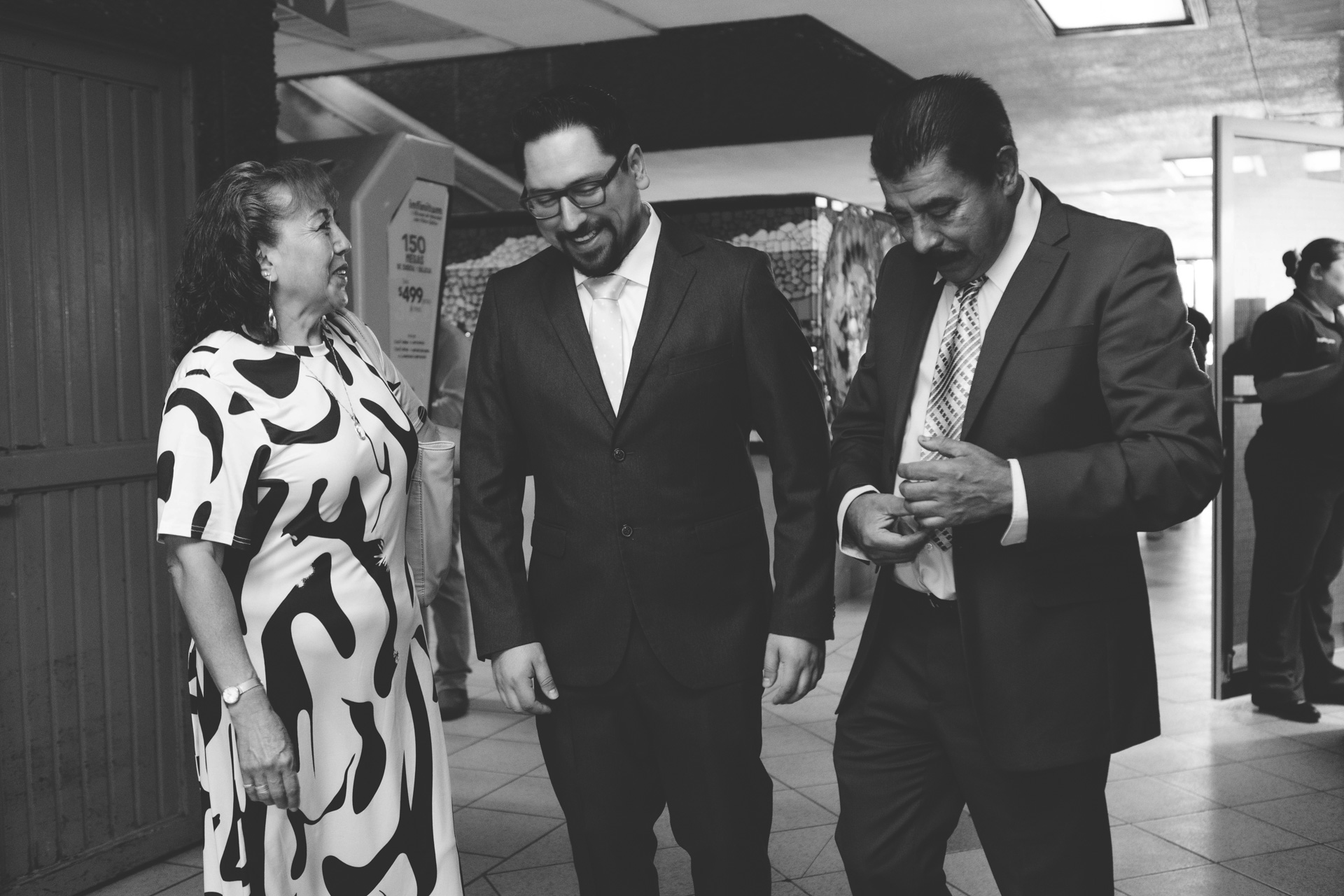 Boda Civil de David y Cristina en Mexicali | Fotógrafos Profesionales y Accesibles – Los Full | Fotografía y Video en Mexicali | 4 | Los mejores fotógrafos y videógrafos en Mexicali Novio caminando y sonriendo acompañado de sus papás antes de la boda, boda civil abril 2025, Registro Civil, Centro Cívico, Mexicali Baja California, fotos de boda baratas pero con calidad, video romántico, los mejores fotógrafos para bodas, quince años, bautizos y más en Mexicali, losfull.com.